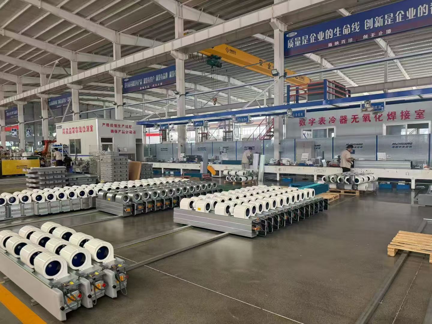 Rows of fan coil assemblies and centrifugal fans in the production area